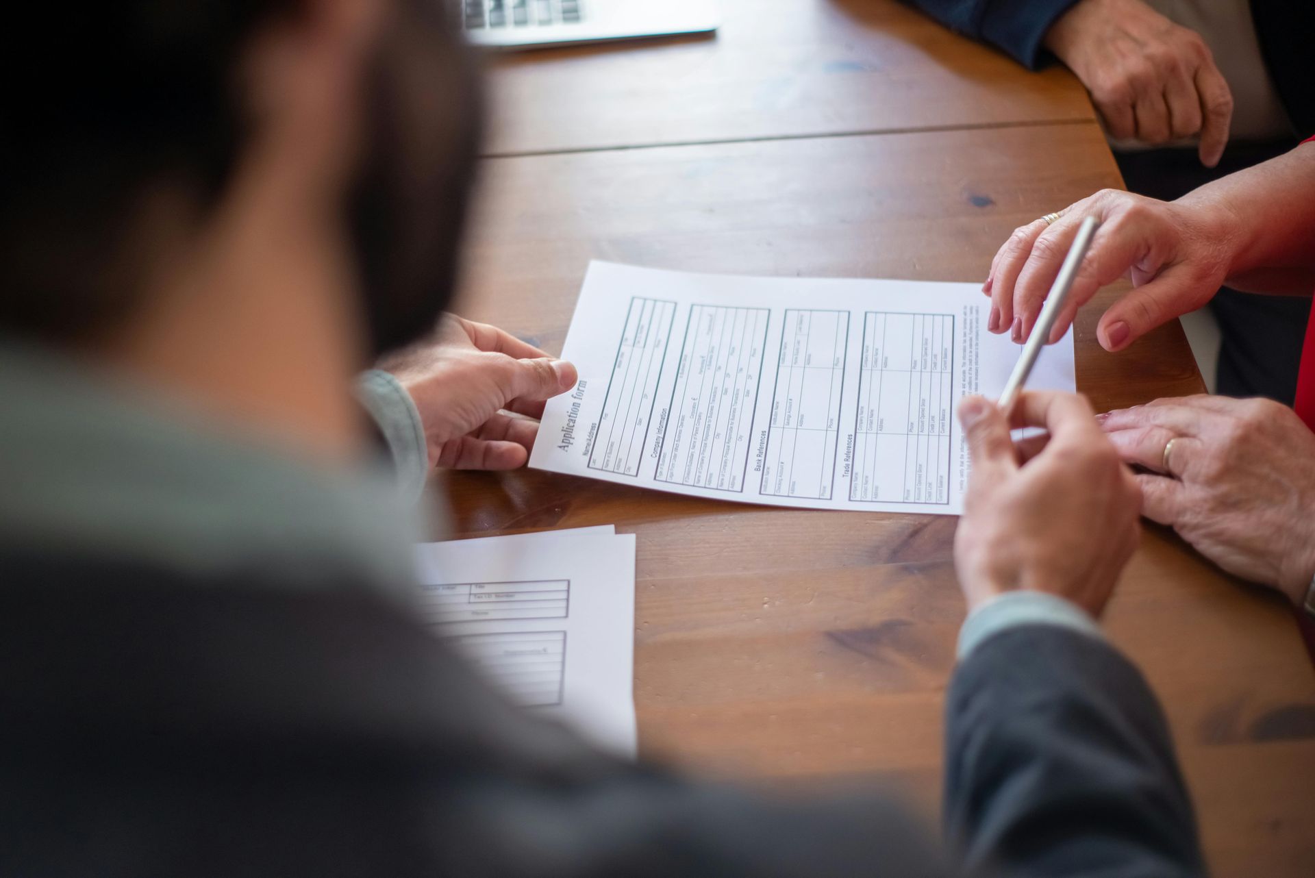 A group of people are sitting at a table looking at a piece of paper.