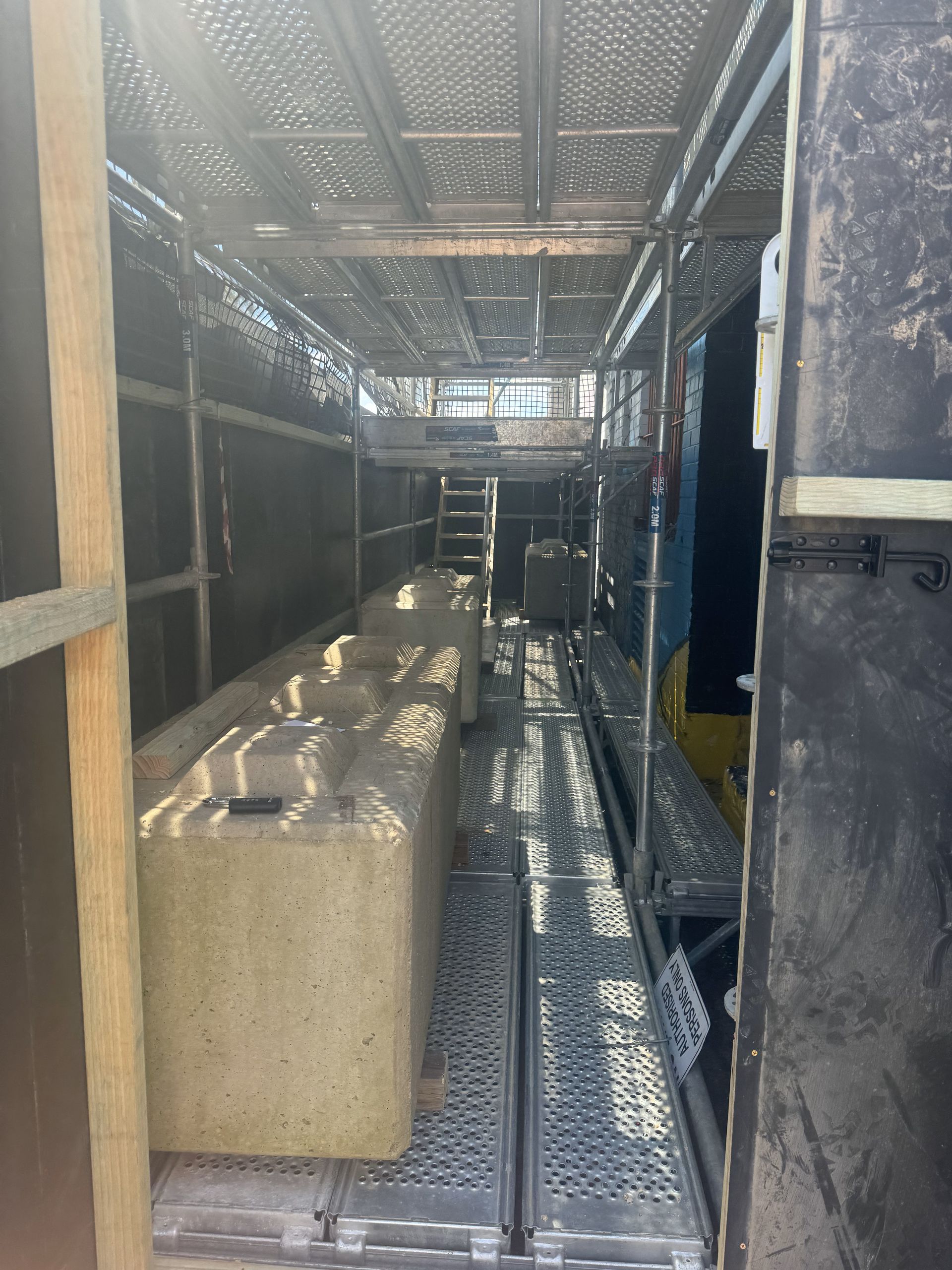 A large concrete block is sitting on top of a metal scaffolding.
