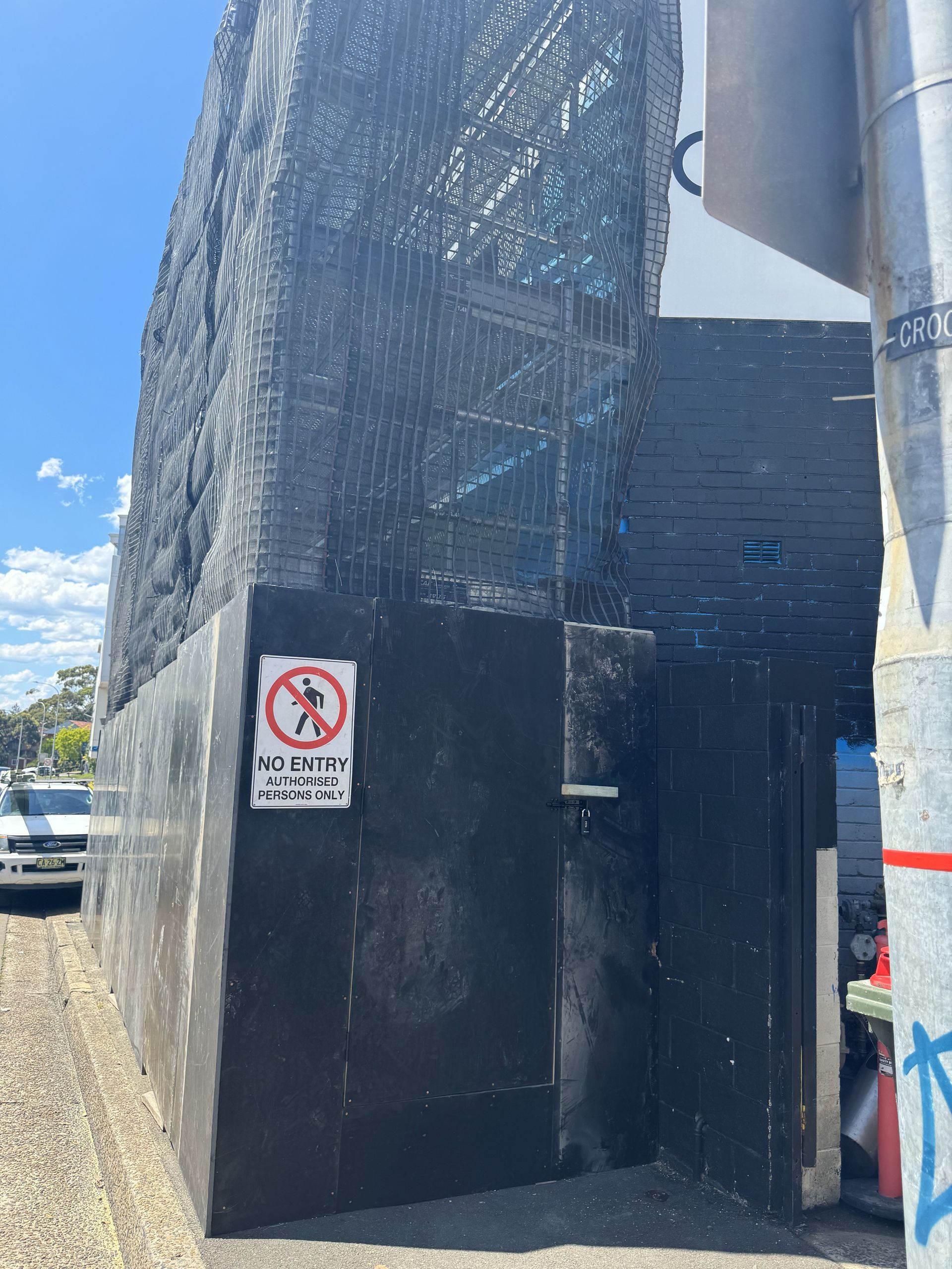 A black building with a no walking sign on the side of it.