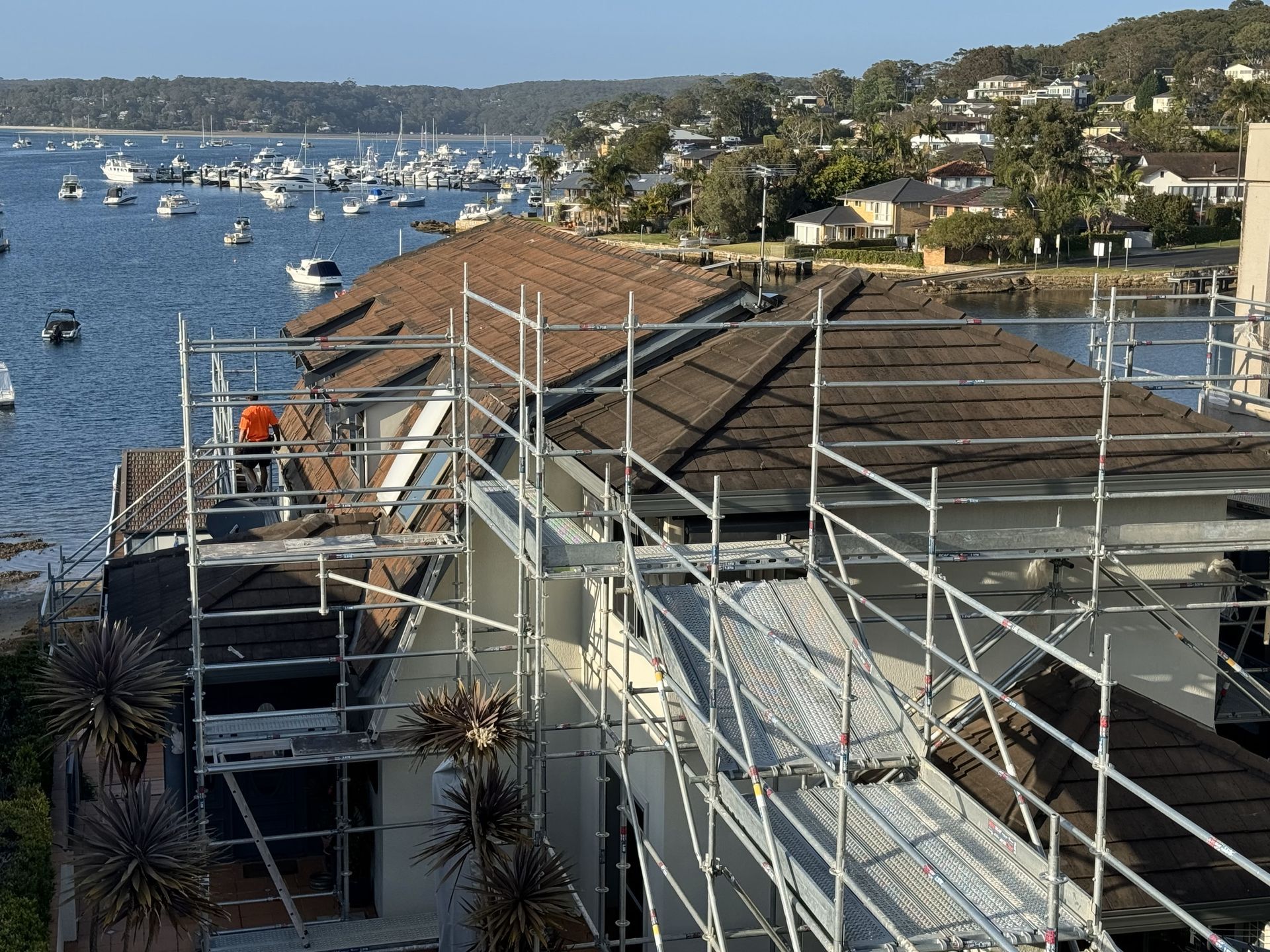 A building is being built next to a body of water.