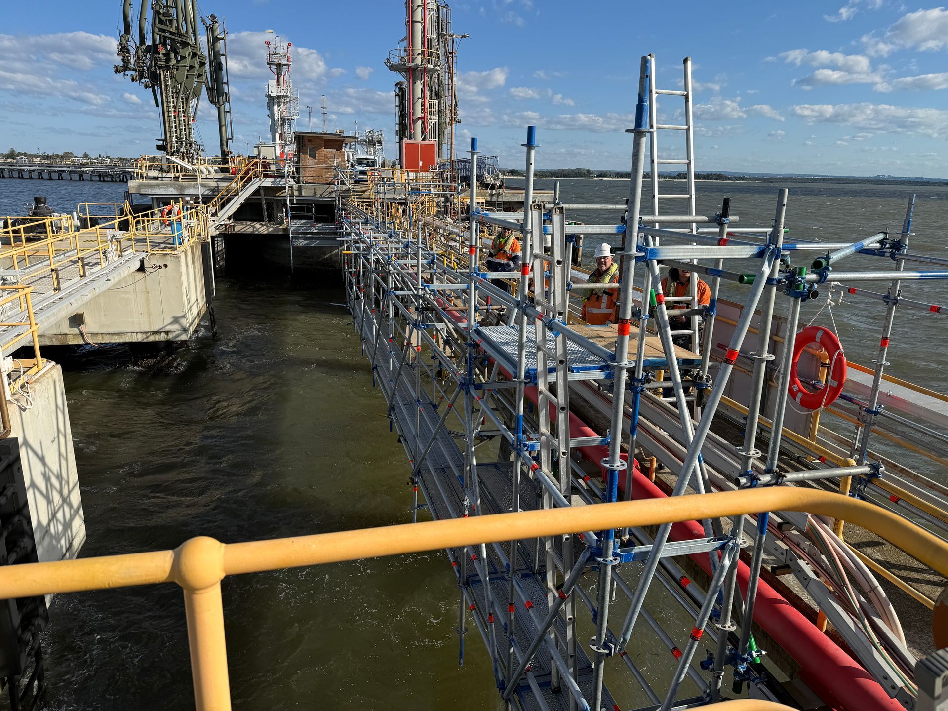 A large ship is docked at a dock with scaffolding around it.