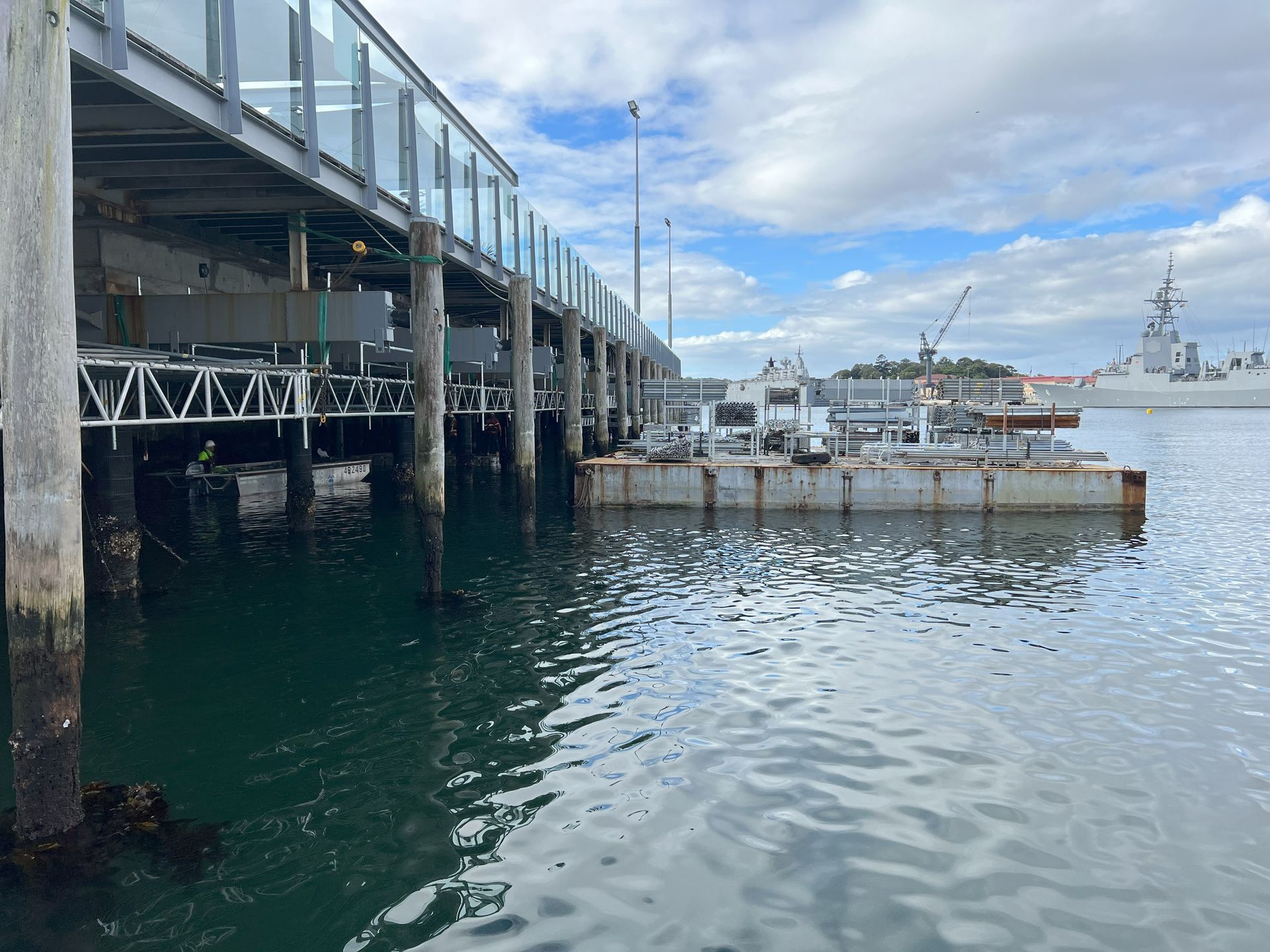 A boat is docked under a pier in the water.