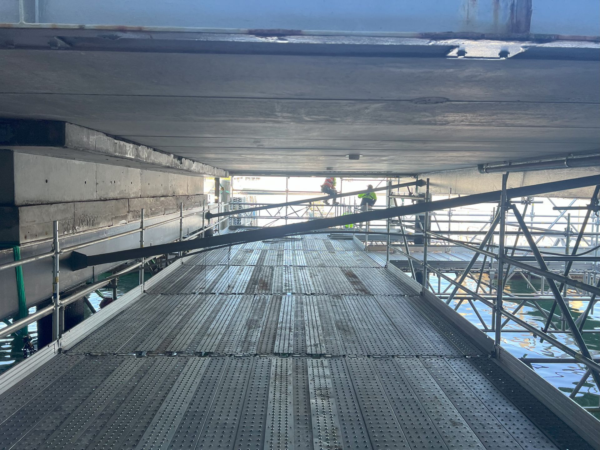 A bridge under construction with scaffolding and workers on it.