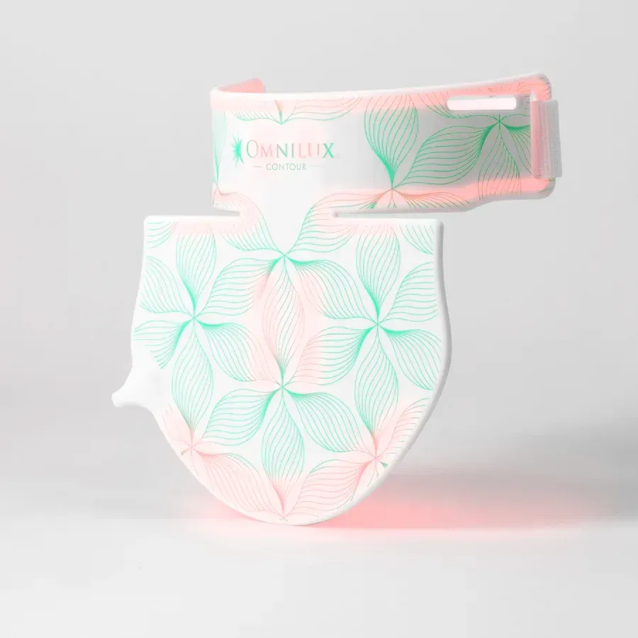 A pink and green bandana with flowers on it is sitting on a white surface.