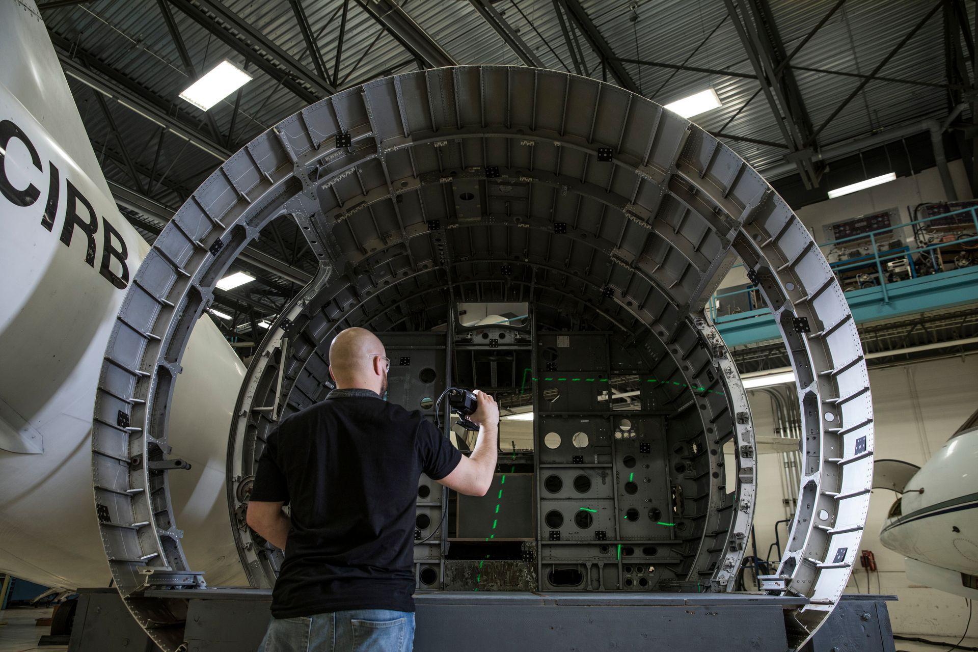 A man is taking a picture of an airplane in a hangar.