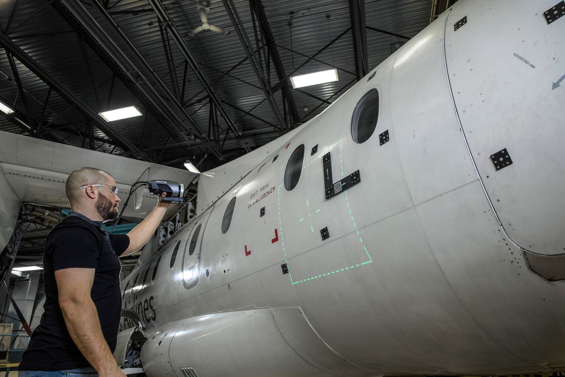 A man is working on an airplane in a hangar.