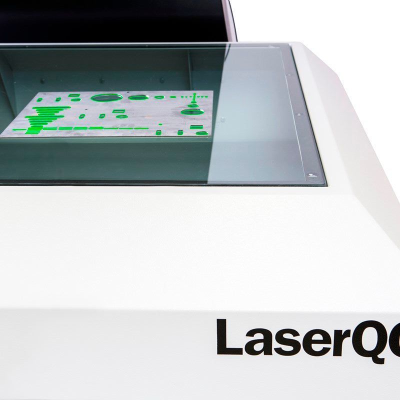 White laser machine with a glass window displaying a green circuit board. The text