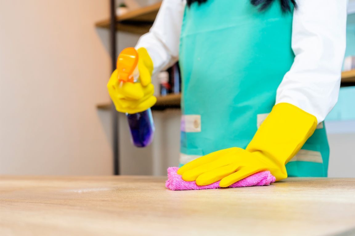 A person is using a yellow vacuum cleaner in a living room.