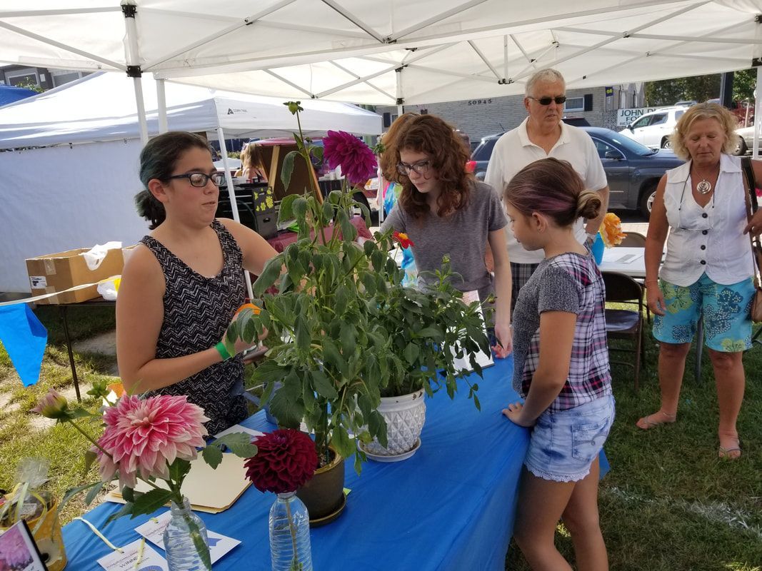 A group of people are standing around a table with flowers on it