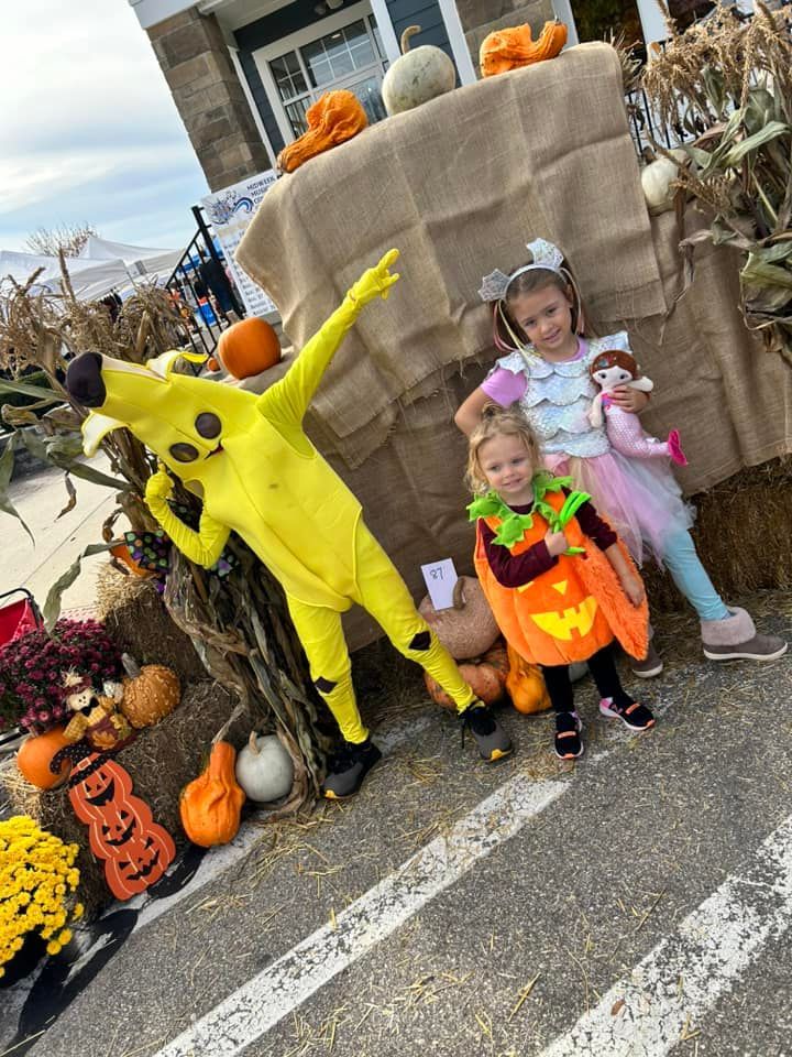 A group of children in halloween costumes are posing for a picture.