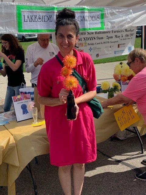 A woman in a pink dress is holding a vase of flowers