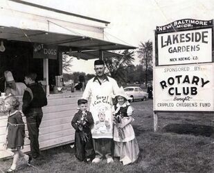 A group of people standing in front of a sign that says lakeside gardens