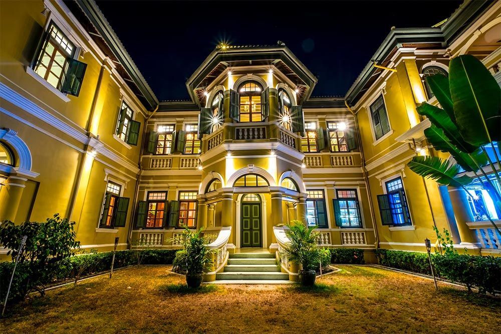 A large yellow building with a lot of windows is lit up at night.
