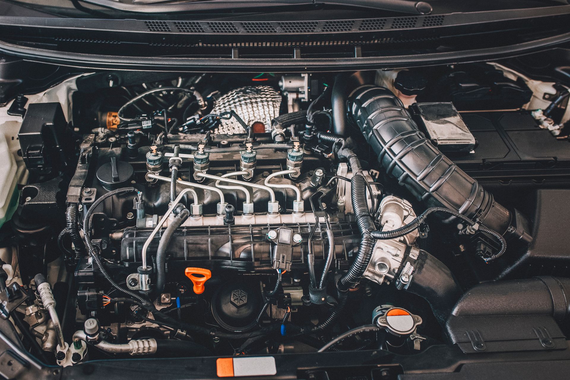A close up of a car engine with the hood open.