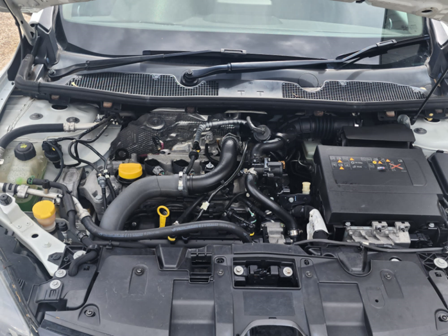 A close up of the engine of a car with the hood open.