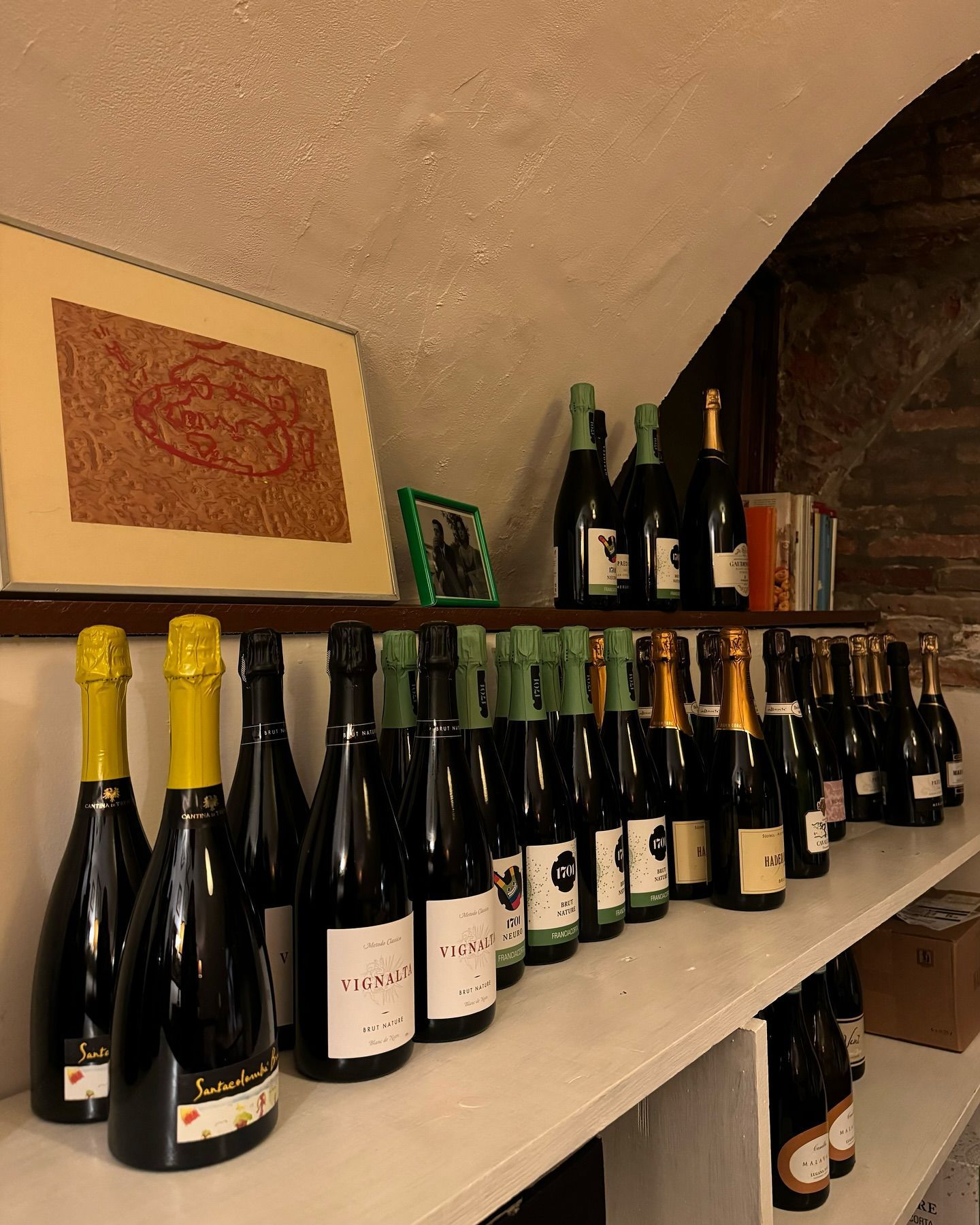 Molte bottiglie di vino sono allineate su uno scaffale