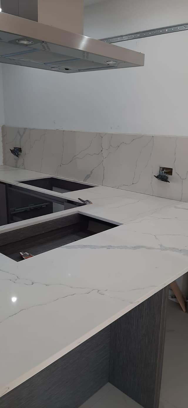 Cucina con piano e parete in marmo bianco