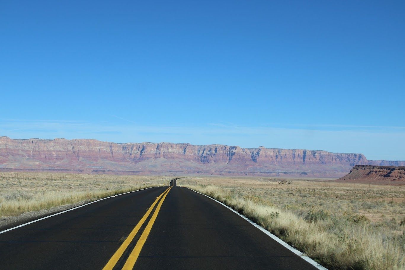 A road in the desert with mountains in the background