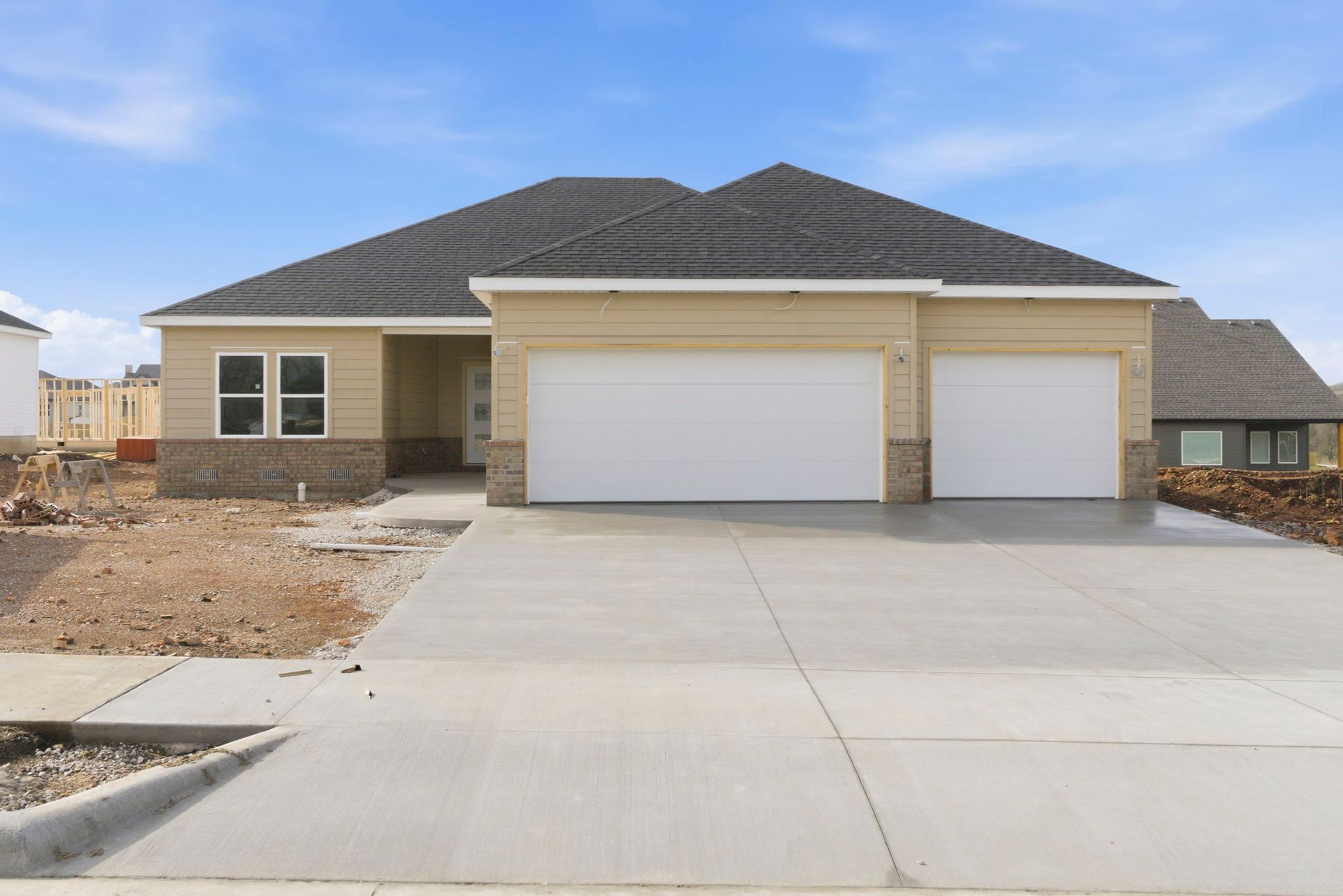 Single-story beige house with a three-car garage and wide concrete driveway