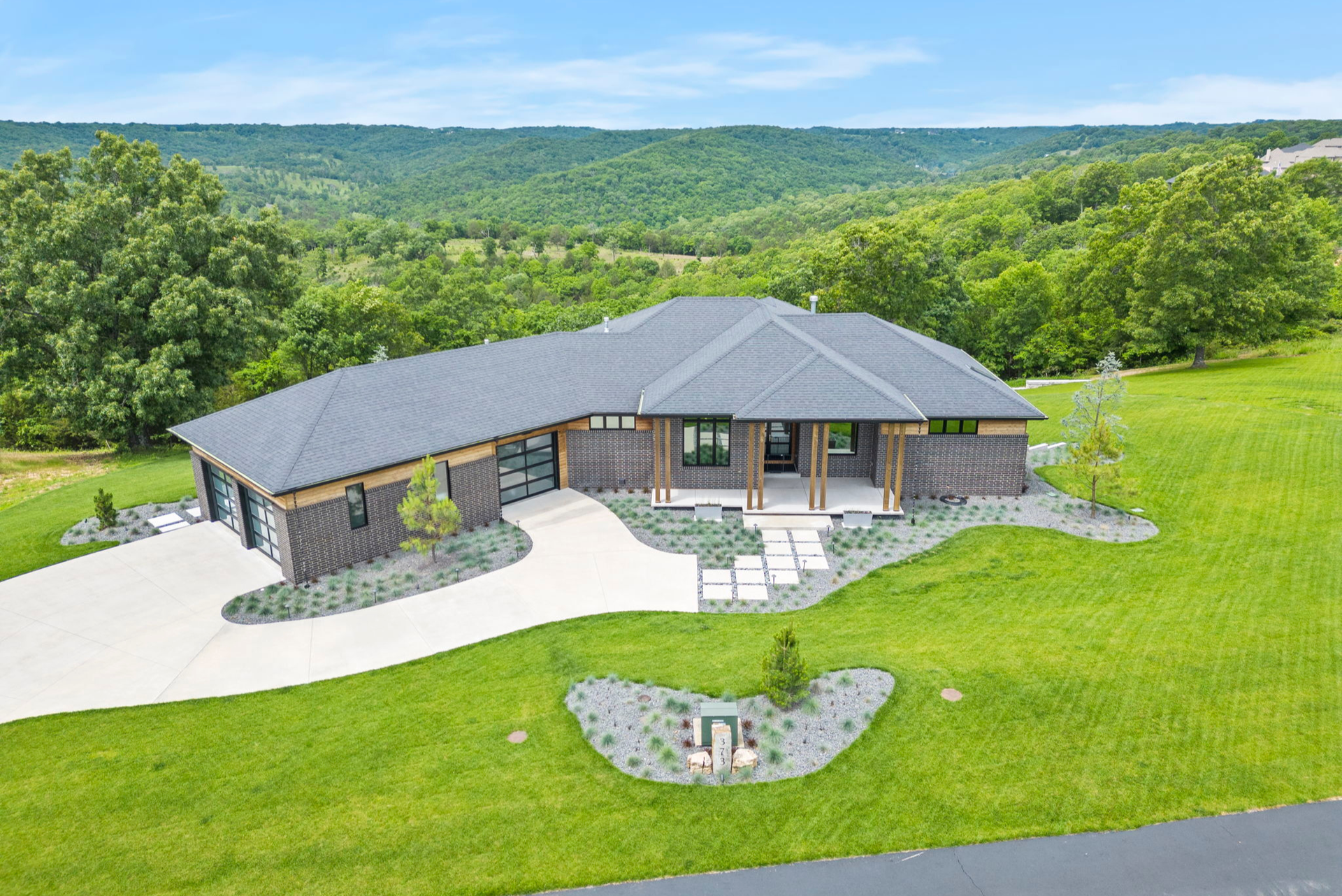 Lakefront cabin surrounded by trees at sunset, overlooking calm water and distant hills