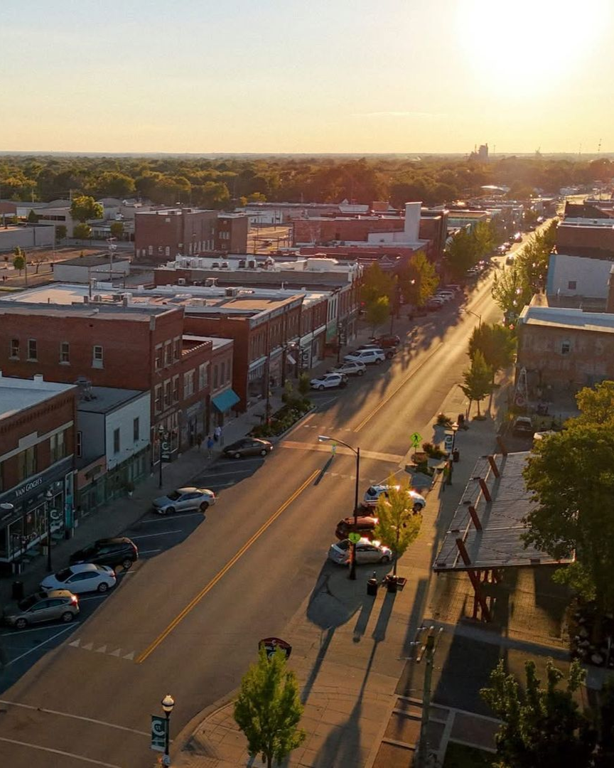 Sunset over a quiet city street with low buildings and long shadows