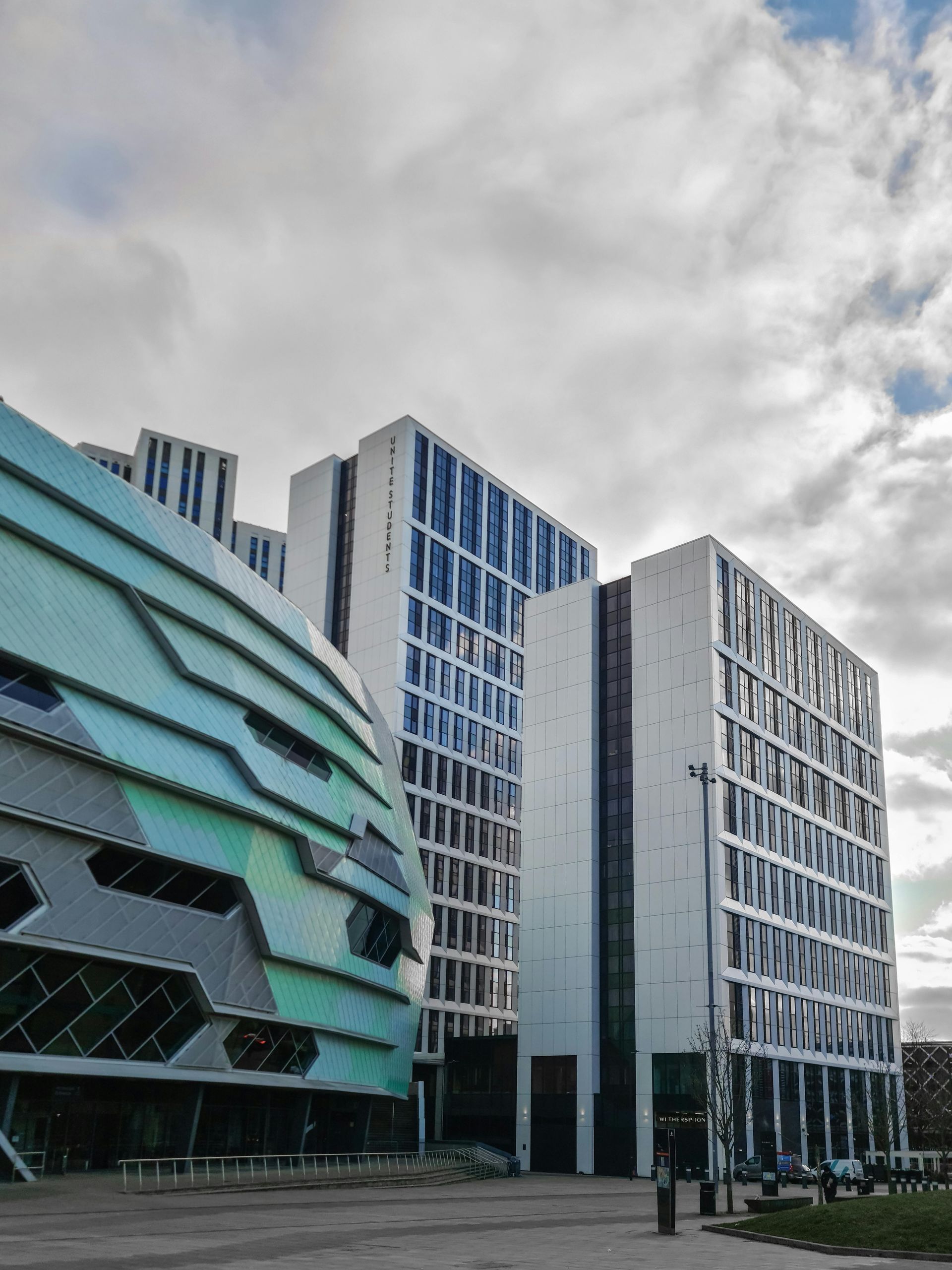 Modern office buildings with blue glass facades under a cloudy sky