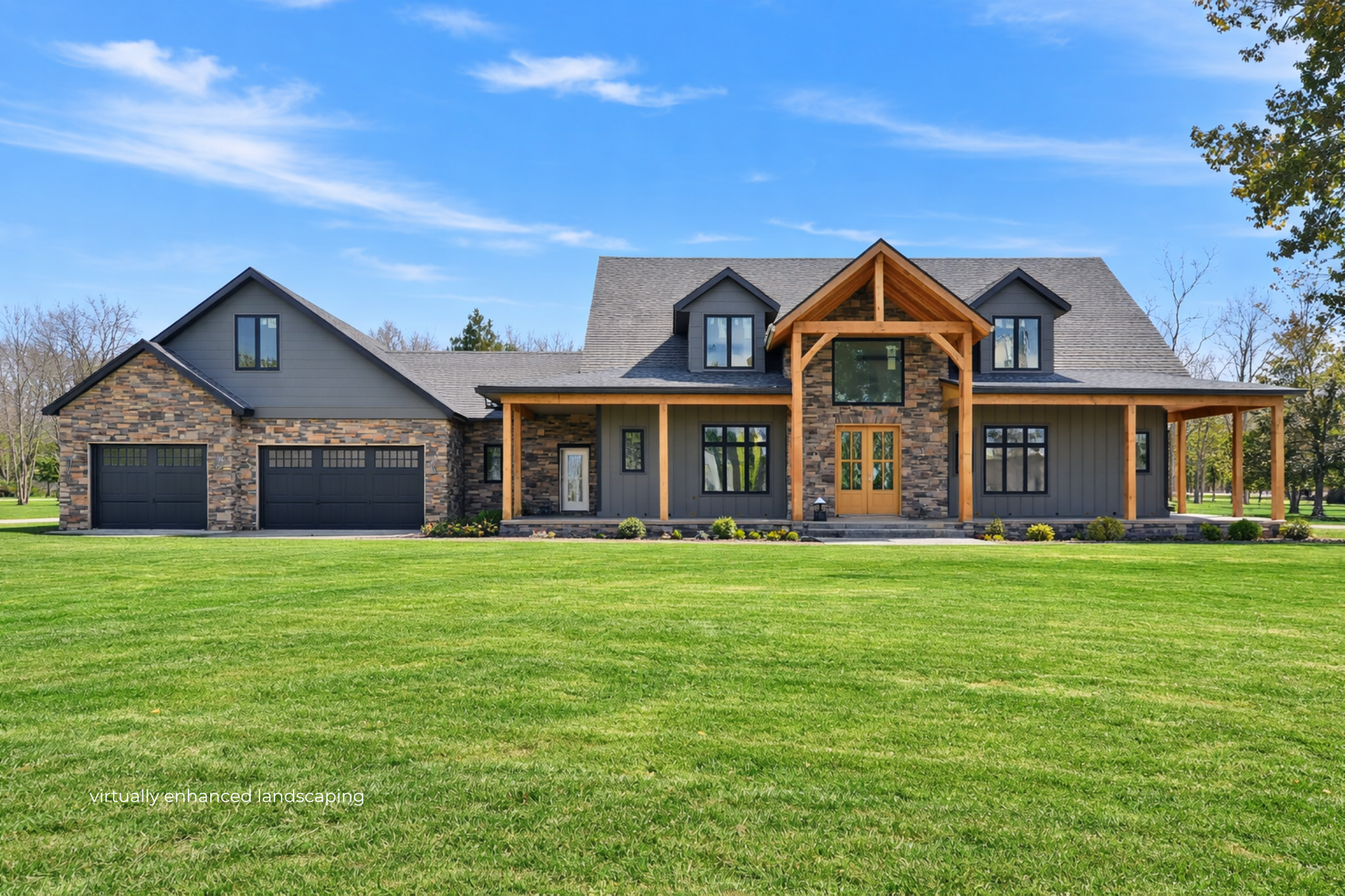 Large modern stone house with a garage and wood accents, set on a wide green lawn under a blue sky