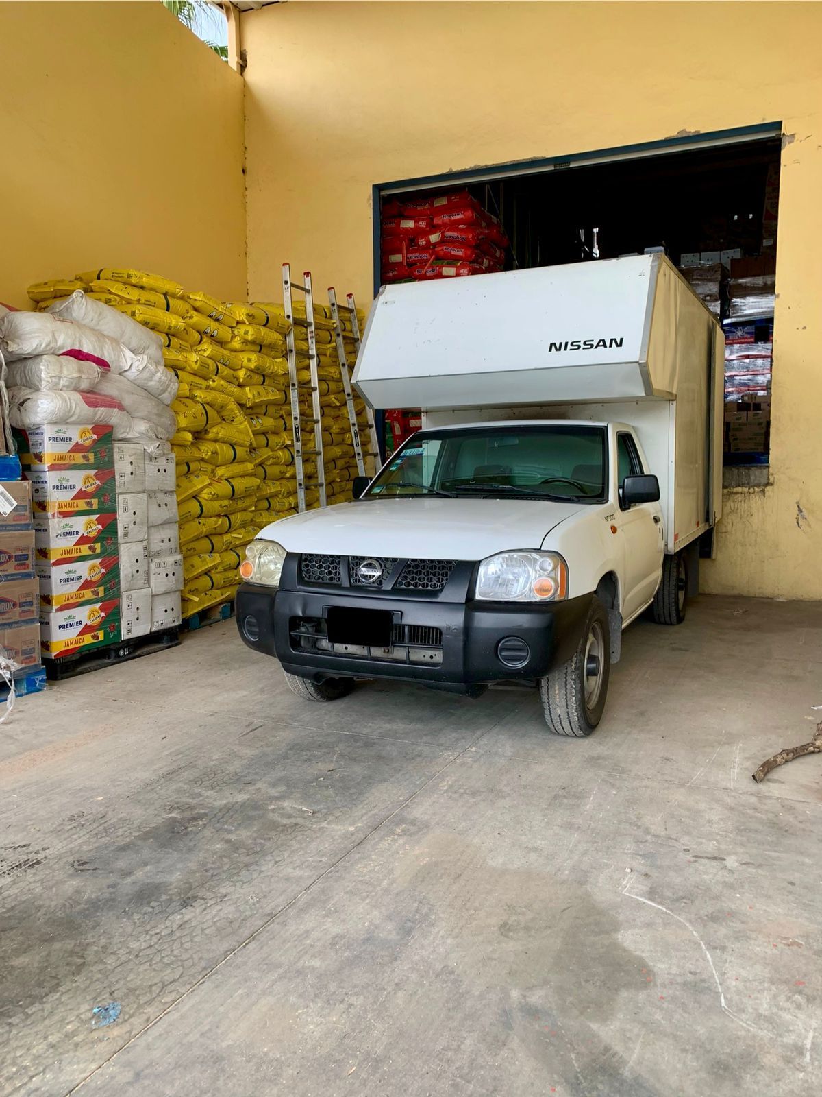 Un camión blanco está estacionado en un estacionamiento frente a un edificio.