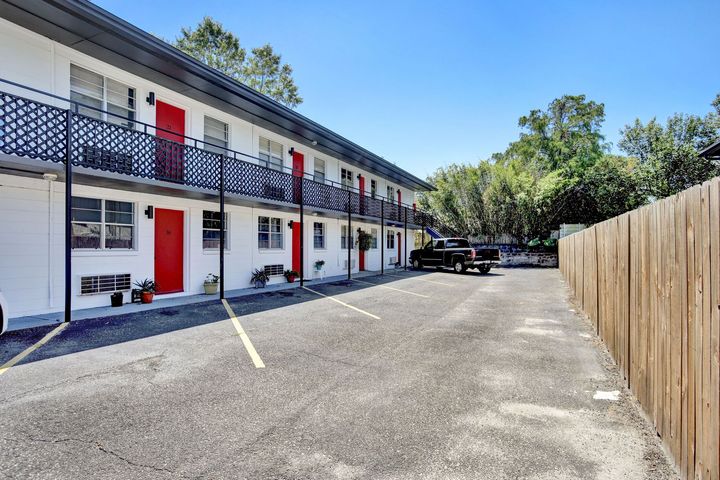 Courtyard apartment complex with exterior stairs, tan walls, and a walkway.