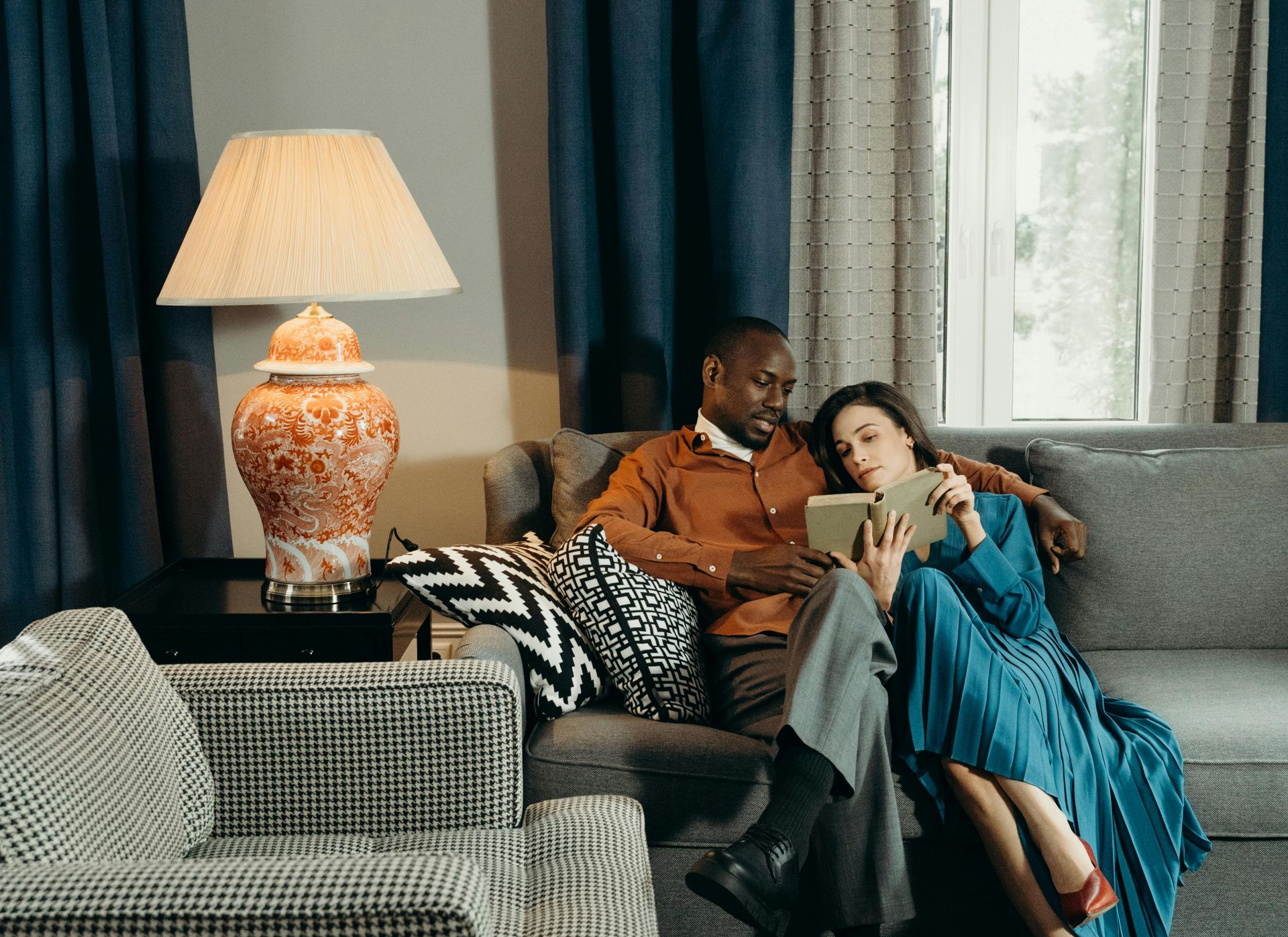 Family of four in light-filled room, mother and father embracing, children watching.