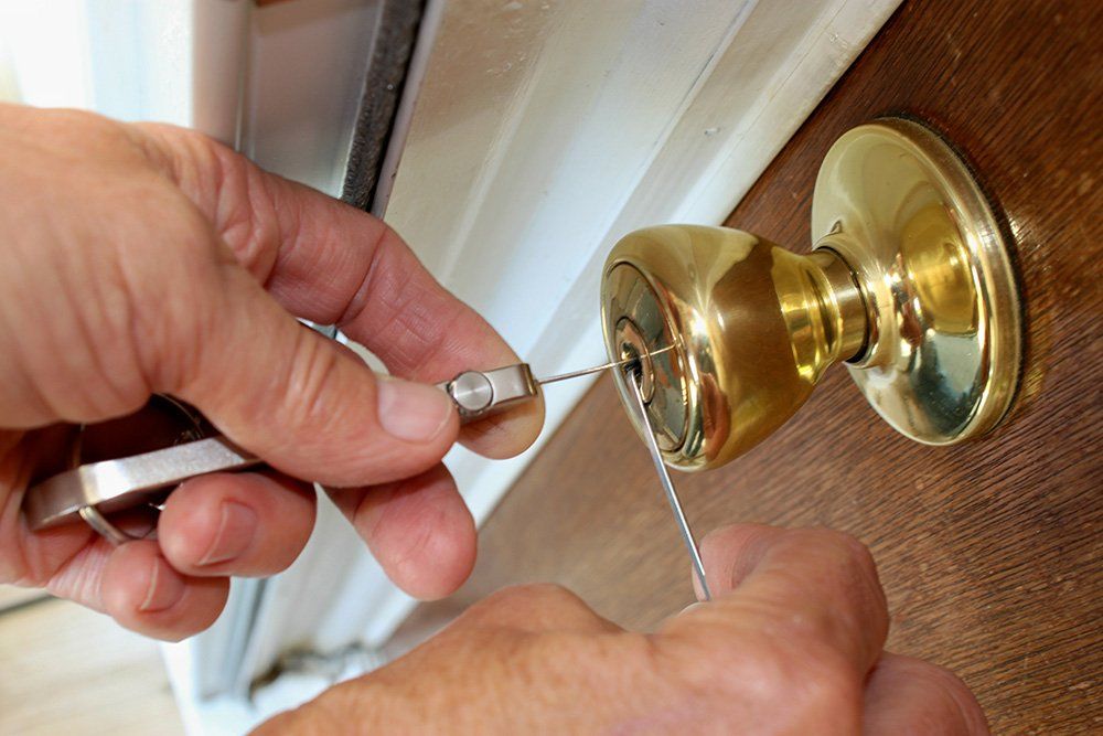A person is using a key to open a door knob.