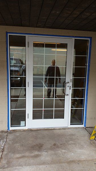 A man is standing in front of a white door.
