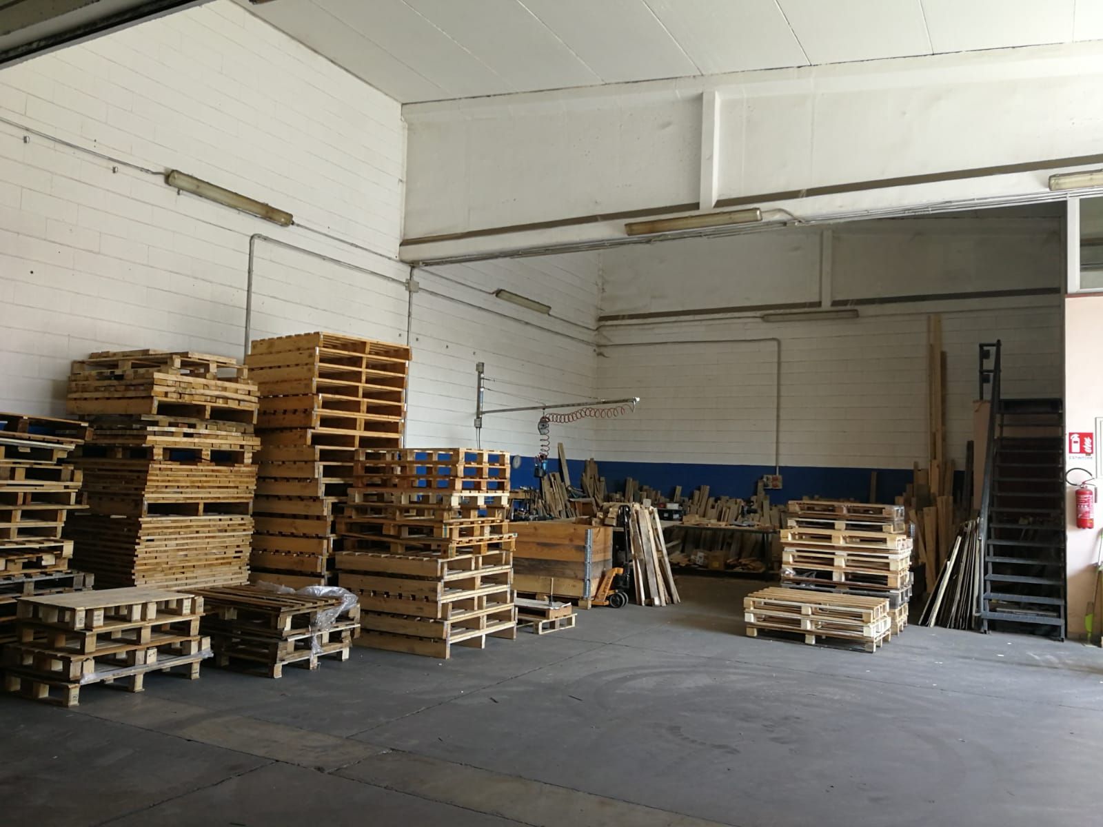 Un magazzino pieno di molti pallet di legno