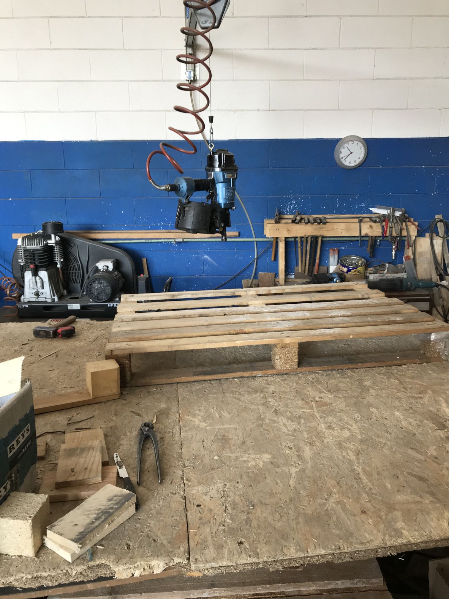 Un pallet di legno è appoggiato su un tavolo di legno in un'officina.