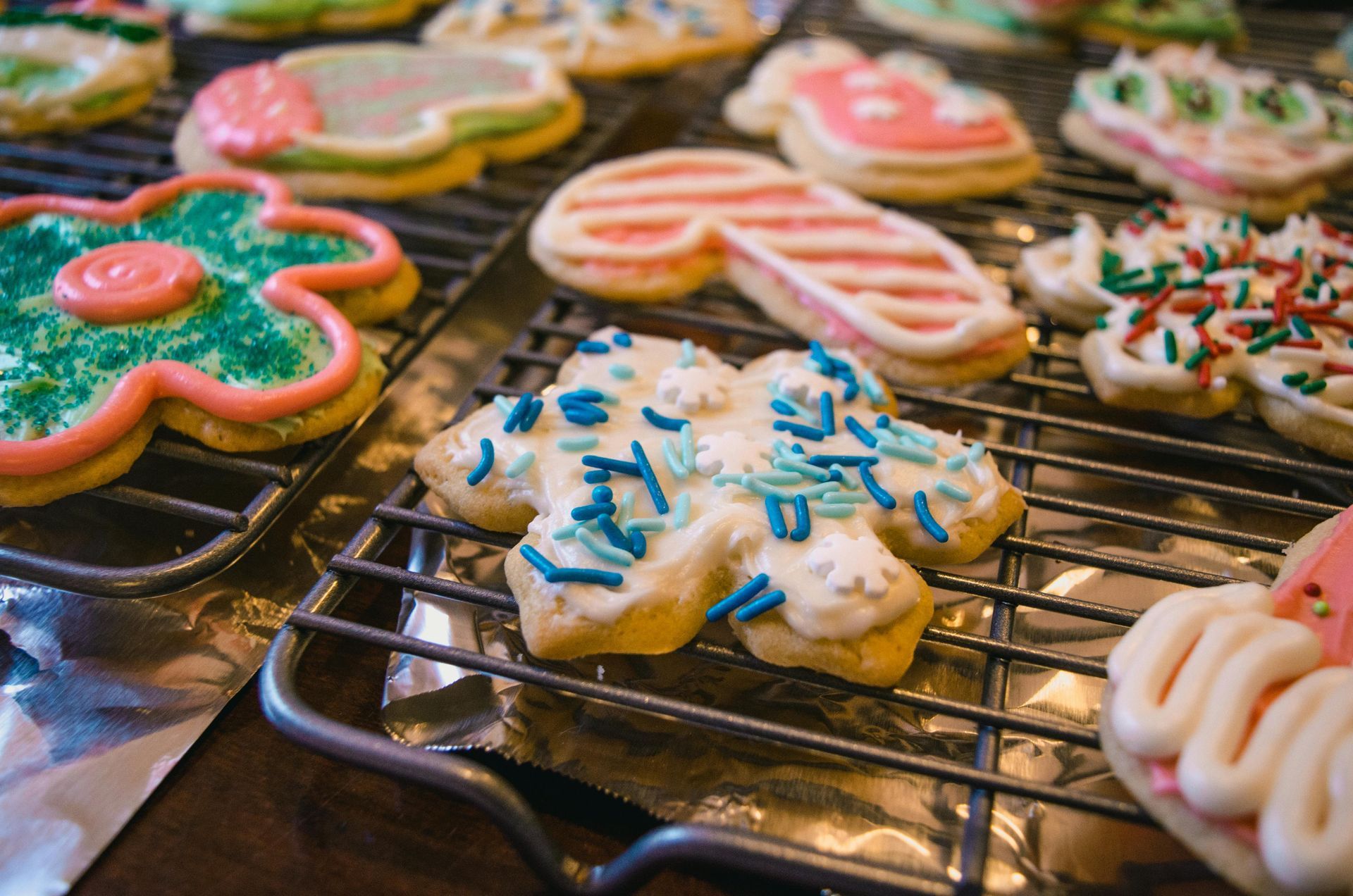 A bunch of decorated cookies are sitting on a cooling rack.