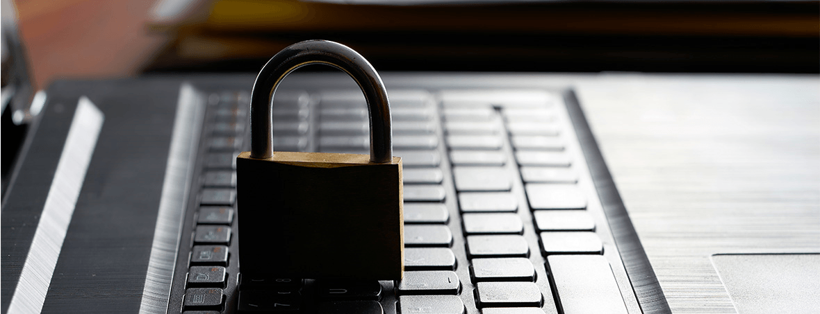 A padlock is sitting on top of a laptop keyboard.