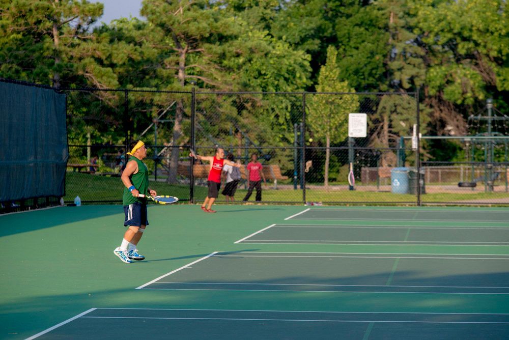 Basketball game: Referee handing ball to smiling player as opponent looks on.