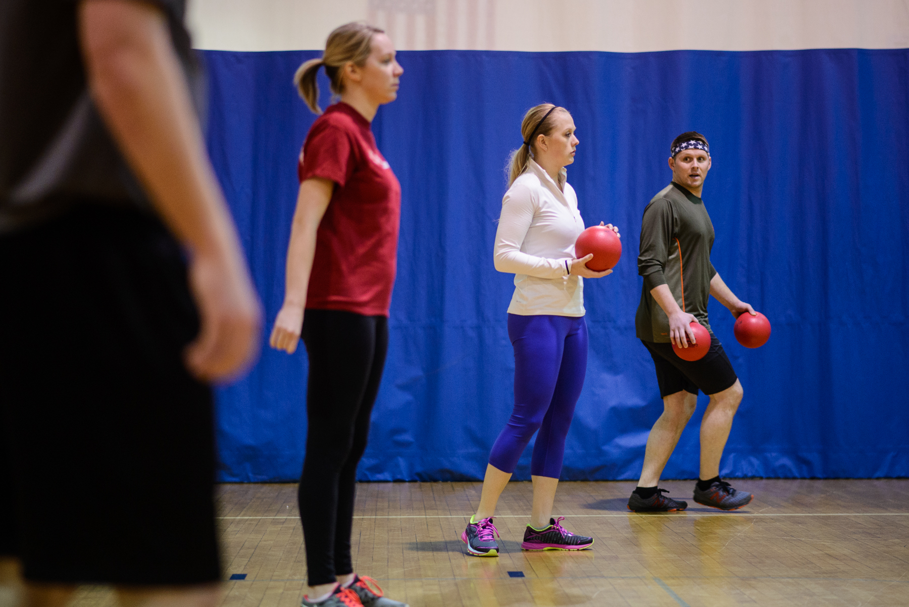 Basketball game: Referee handing ball to smiling player as opponent looks on.