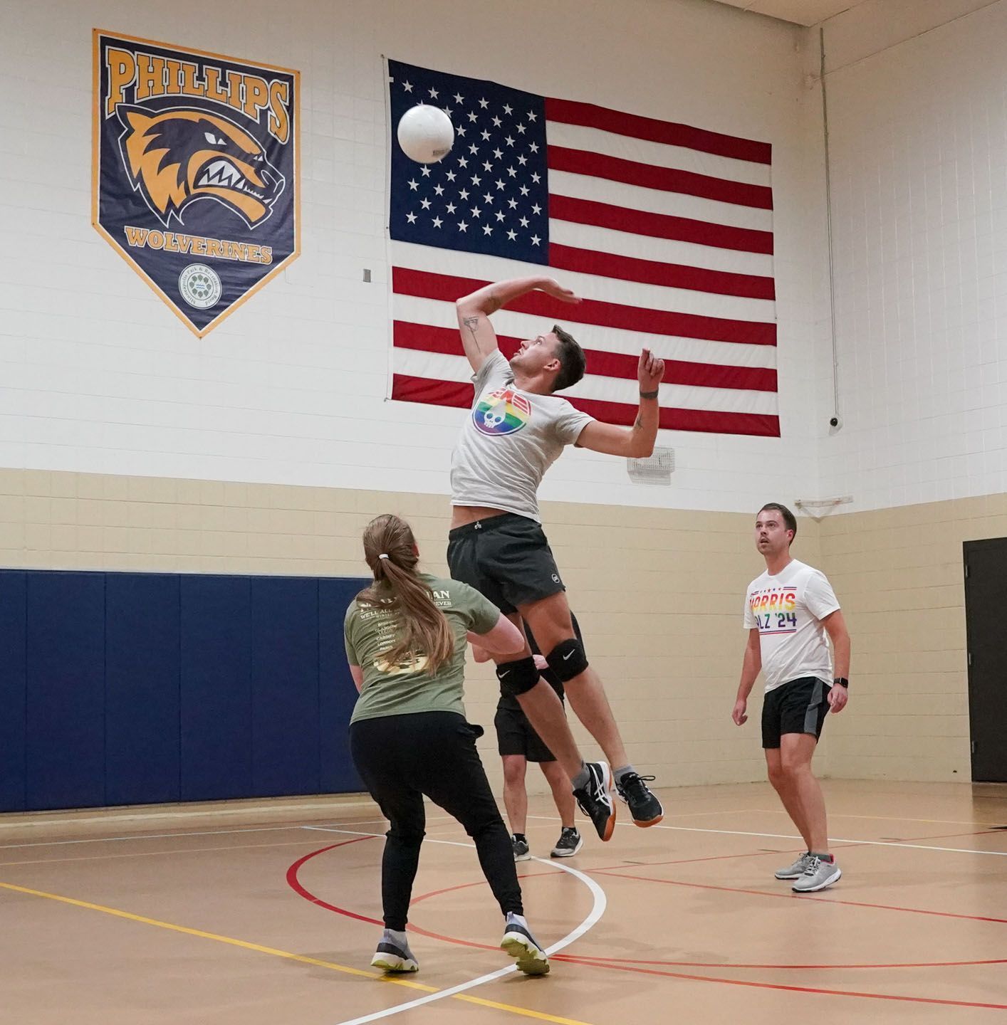 Basketball player holding ball, defended by a player with raised arms in indoor court setting.