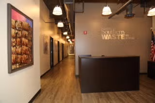 Modern office lobby with wood floors, reception desk, hallway, and wall art