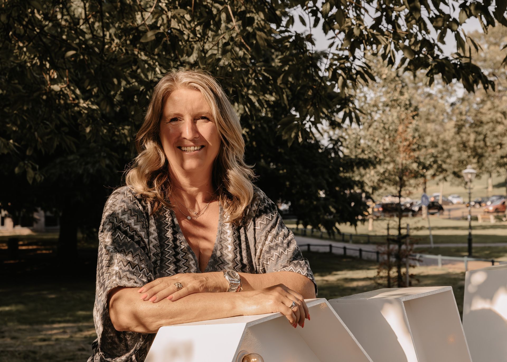 Portret van trouwambtenaar Marijke in de buitenlucht, ontspannen en warm, passend bij haar persoonlijke stijl als ceremoniespreker.