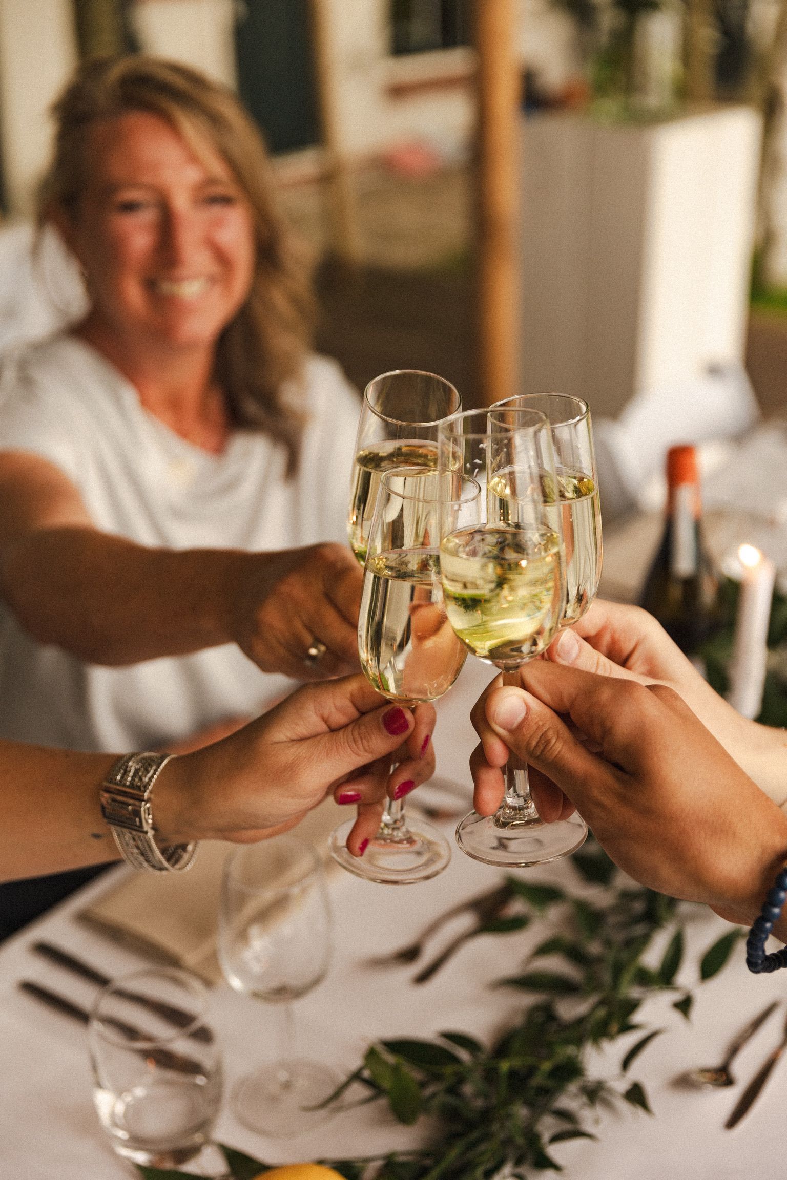 Marijke proost met champagne tijdens een intiem huwelijksmoment vol warmte en gezelligheid.