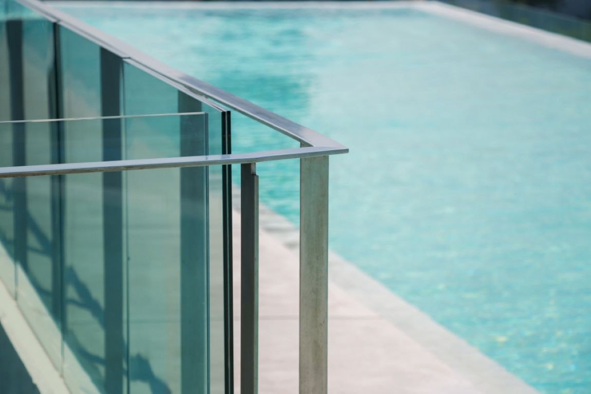 A Swimming Pool With a Glass Railing and a Stainless Steel Railing — Tuggerah Lakes Glass In Tumbi Umbi, NSW
