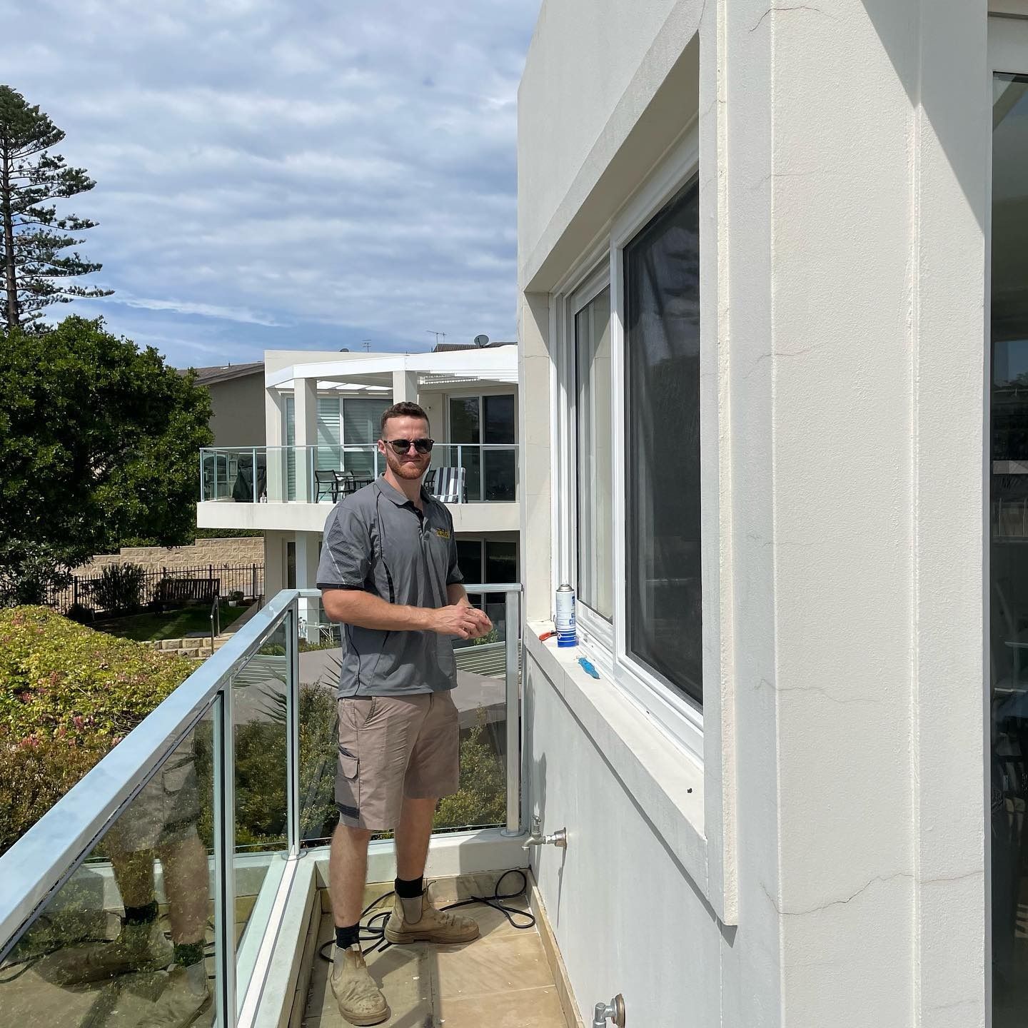 Glazier Installing Window Glass Outside a House