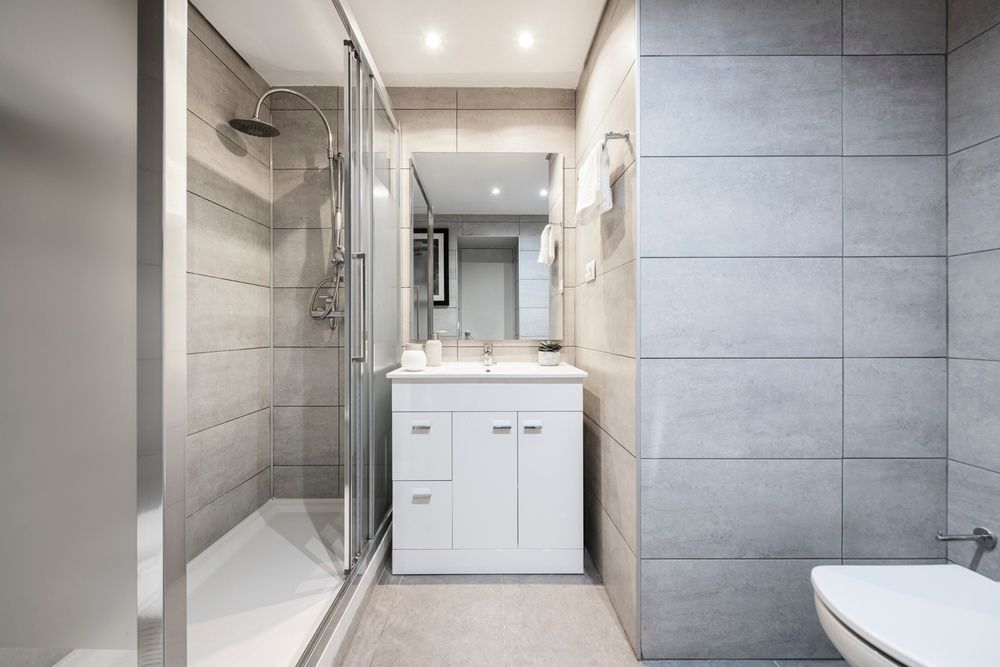 A Bathroom With Marble Tiles and a Walk in Shower With a Glass Door — Tuggerah Lakes Glass In Tumbi Umbi, NSW