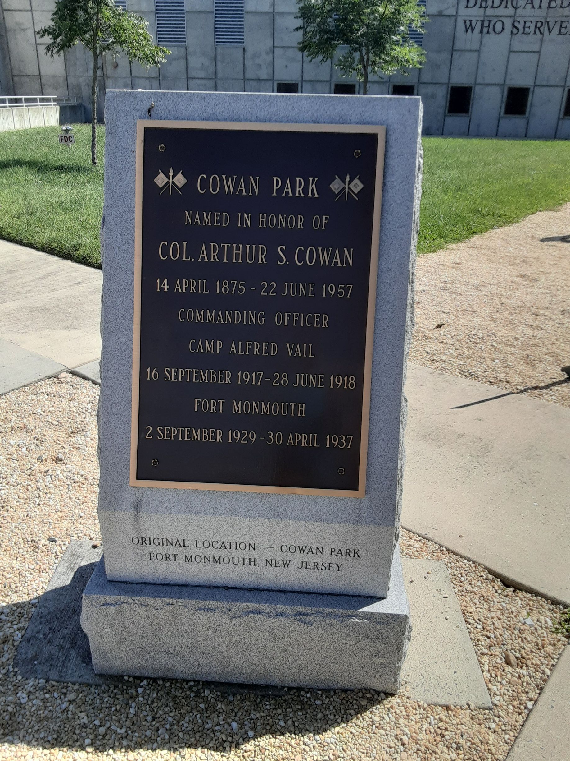 Memorial plaque in a park, bronze text on stone base.