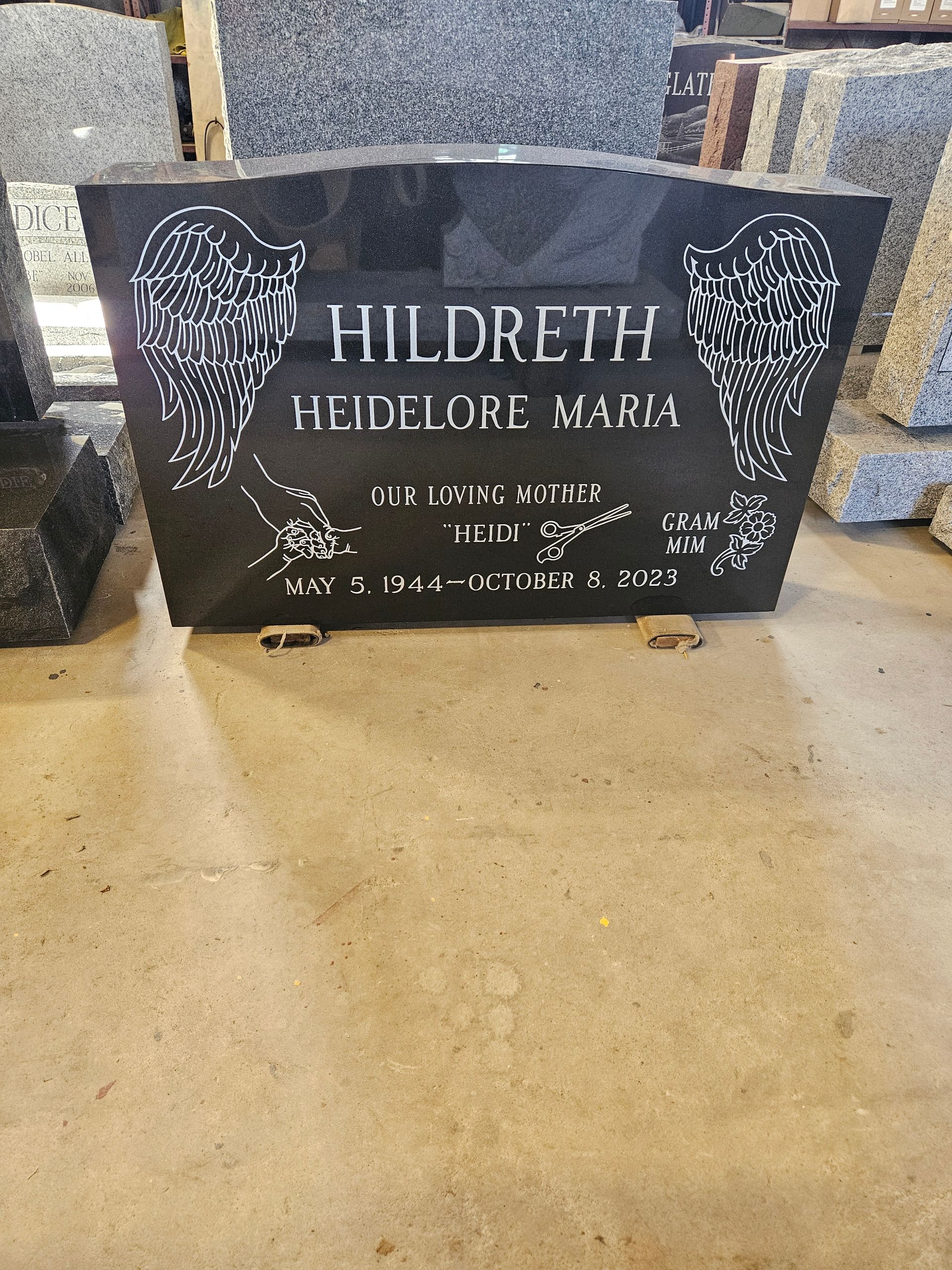 Black granite headstone with white lettering, featuring