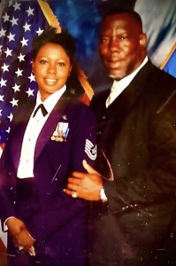 Two people posing in formal attire in front of a blue, starry backdrop