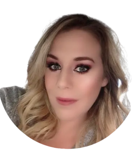 Close-up selfie of a person with wavy blonde hair and smoky eye makeup against a white background