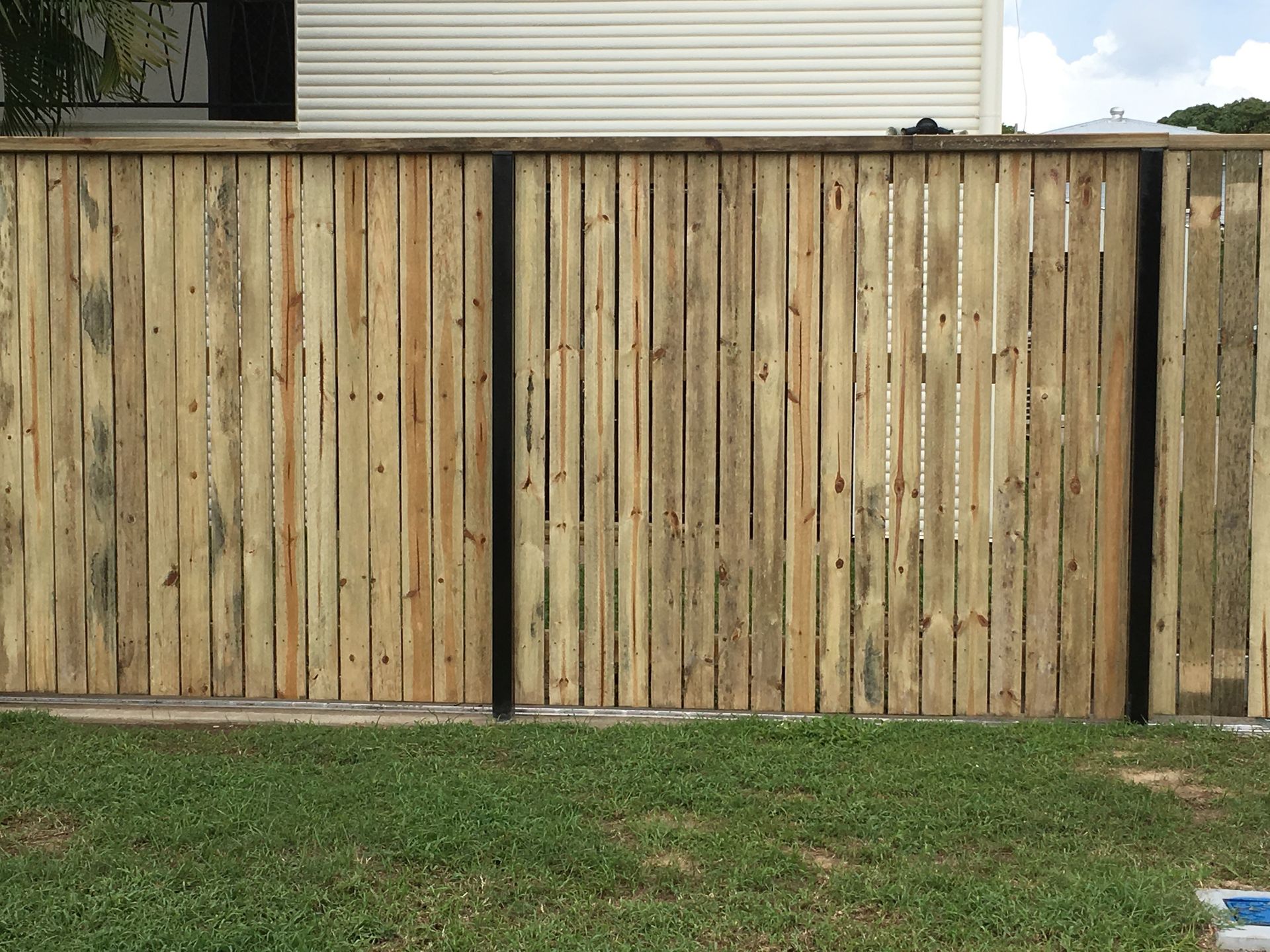 Wooden Privacy Fence With Vertical Slats Along a Grassy Yard — Fencing Around in Garbutt, QLD